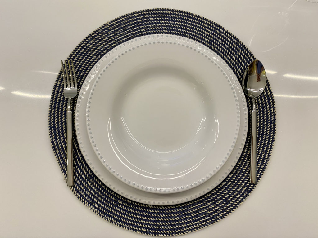 zara home的藍色竹編餐墊搭配藍點白盤的擺設